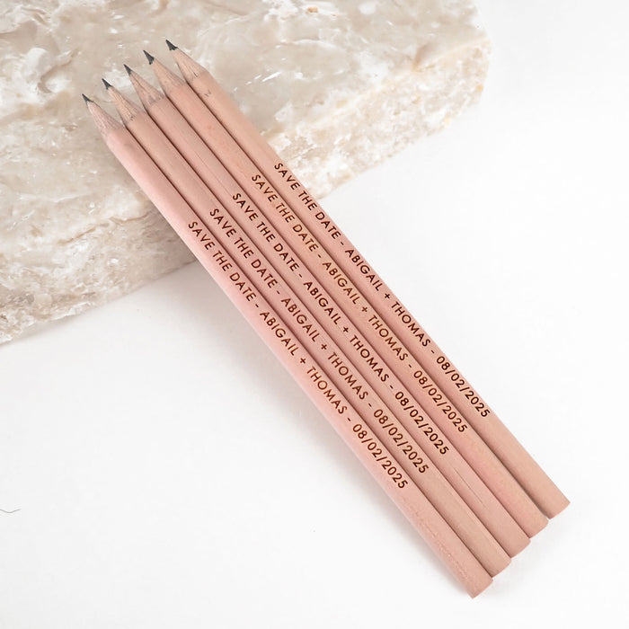 Personalised engraved wooden save the date pencils.