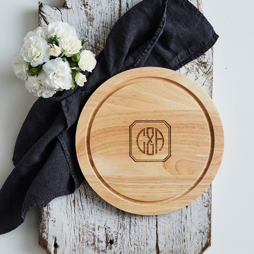 Personalised wooden cheese board with engraved housewarming design.