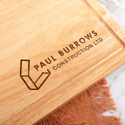 Personalised wooden serving board with engraved business logo, styled with cheese and wine