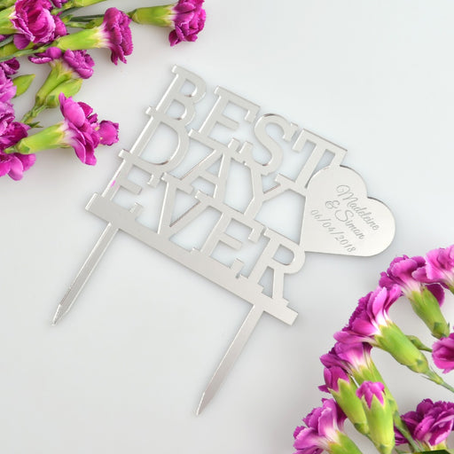 Black acrylic personalised wedding cake topper with names and date displayed on white cake