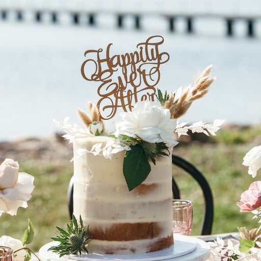Natural wood laser-cut “Happily Ever After” topper displayed on garden wedding cake