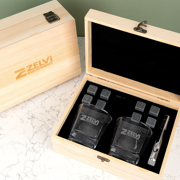 Premium corporate whiskey gift set featuring personalised glasses, whiskey stones, tongs and a velvet storage pouch presented in a wooden gift box.
