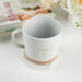 Custom coffee mug wrapped in brown kraft paper with white satin ribbon