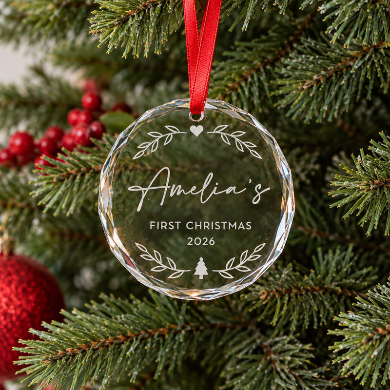 Round glass Christmas ornament with crystal-cut edges and red ribbon