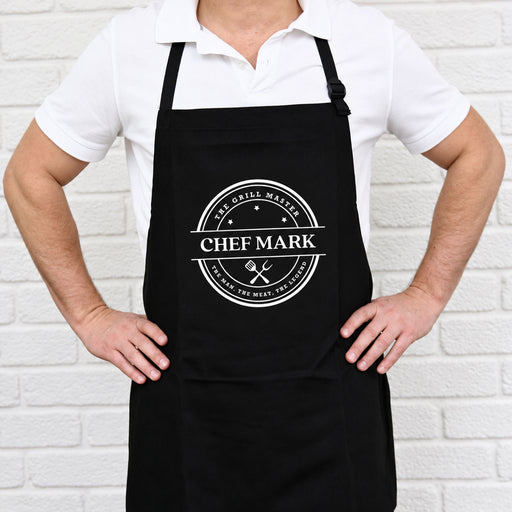 Personalised black BBQ apron with bold white print and custom name, a practical gift for Dad, Grandad or the BBQ King.