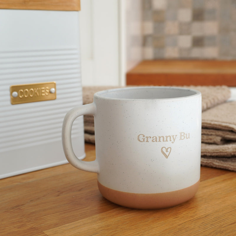 White ribbed cookie tin with gold badge and custom mug