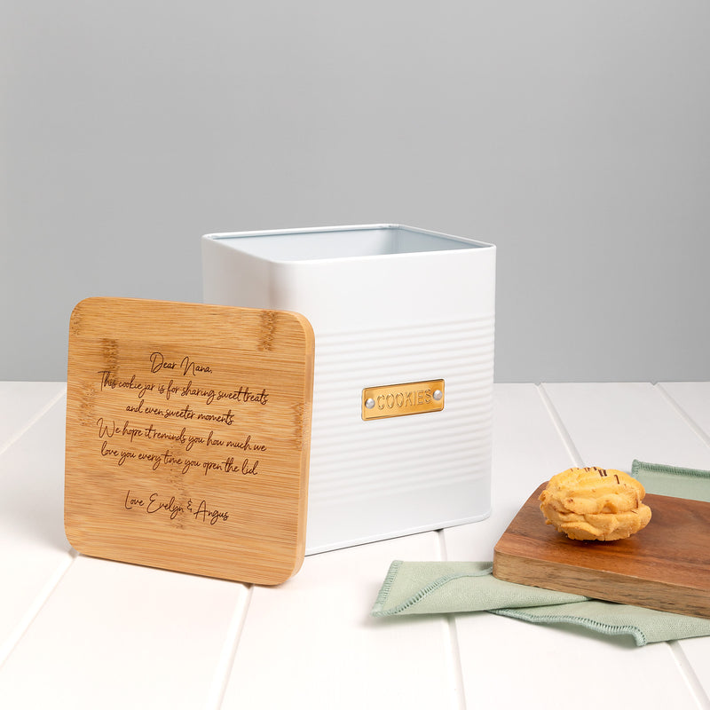 Gift-wrapped personalised cookie tin with kraft paper and white satin ribbon, perfect for special occasions.