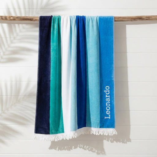 Blue striped beach towel with white fringing and embroidered name